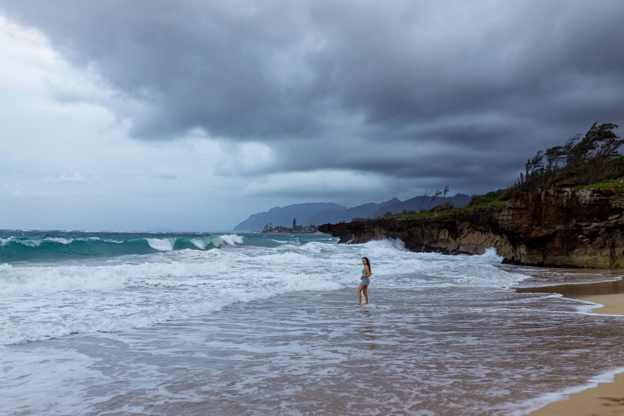 Woman walking along a beach shoreline